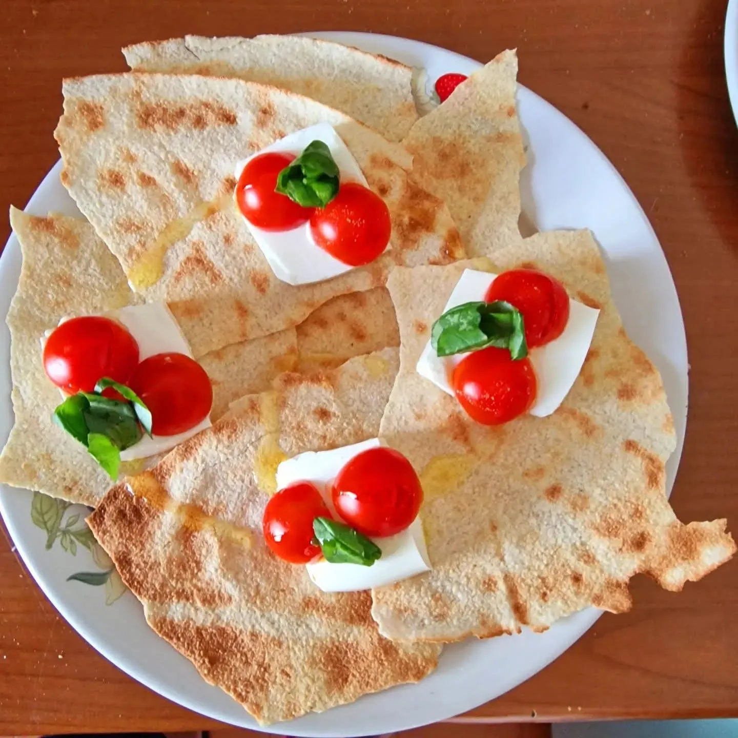 Pane carasau con mozzarella, pomodorini e basilico servito a colazione