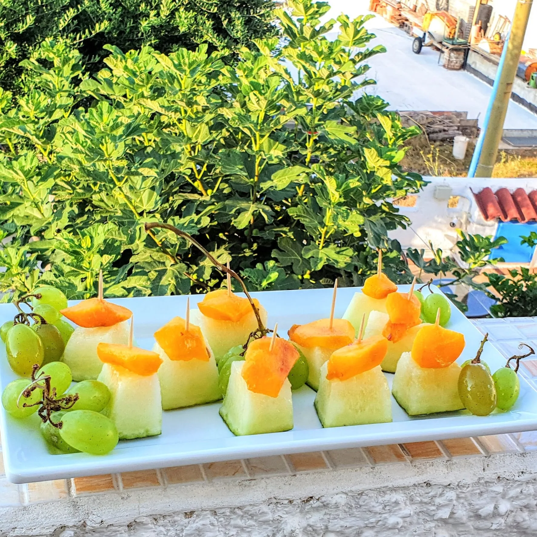 Spiedini di frutta fresca con melone, pesca e uva sulla terrazza del B&B