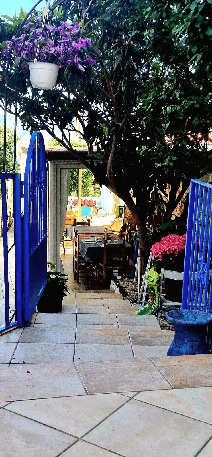 L’ingresso del B&B con il cancello azzurro e la saletta della colazione apparecchiata